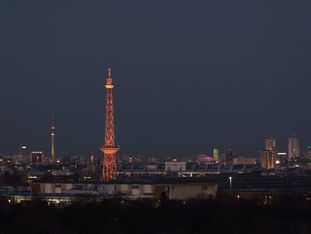 Illuminated cityscape against clear sky at night