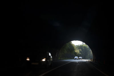 Cars on road in illuminated tunnel