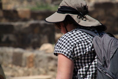 Rear view of woman wearing hat and backpack