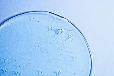 Close-up of water drop on colored background