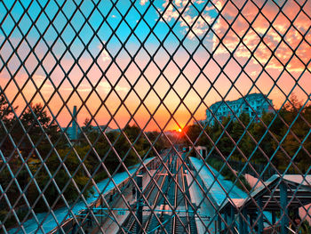 Chainlink fence against sky during sunset