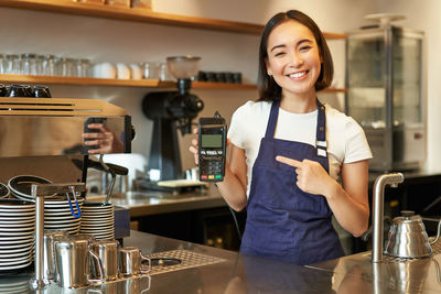 Portrait of young woman standing in cafe