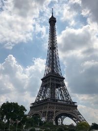 Low angle view of communications tower against cloudy sky