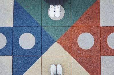 Low section of man standing on tiled floor
