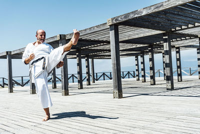 Karate man practicing a kick in the air.