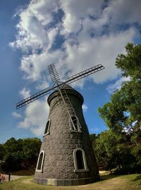 Low angle view of traditional windmill against sky