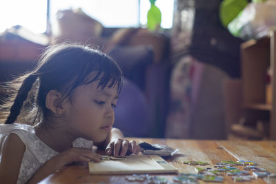 Portrait of cute girl looking at table