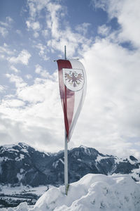 Information sign on snow covered mountain against sky