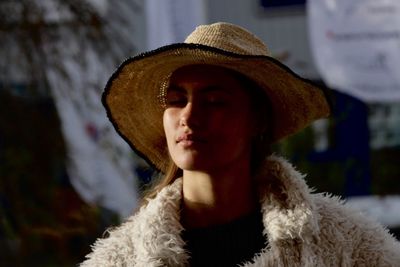 Close-up of young woman with eyes closed wearing warm clothing