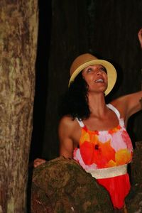 Portrait of a smiling young woman against tree trunk