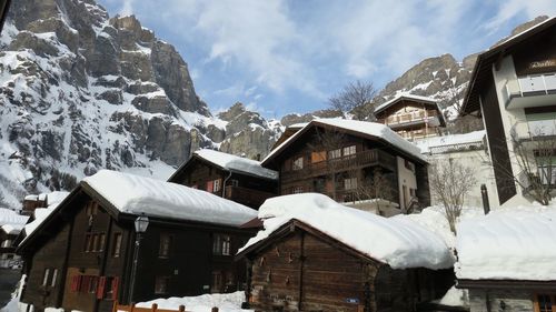Snow covered houses and buildings against sky