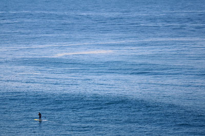 Atlantic ocean with man on paddleboard, copacabana beach, rio de janeiro, brazil