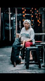 Portrait of woman with dog sitting on seat