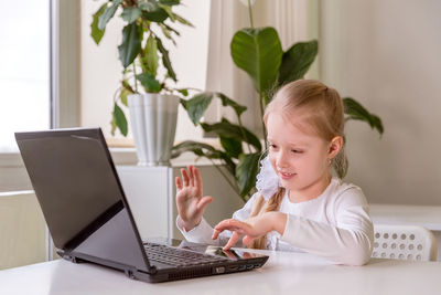 The girl learns, communicates, talks, through a computer / laptop