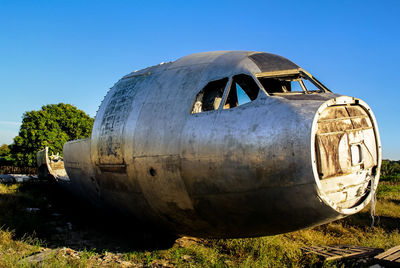 Abandoned airplane on field against clear sky