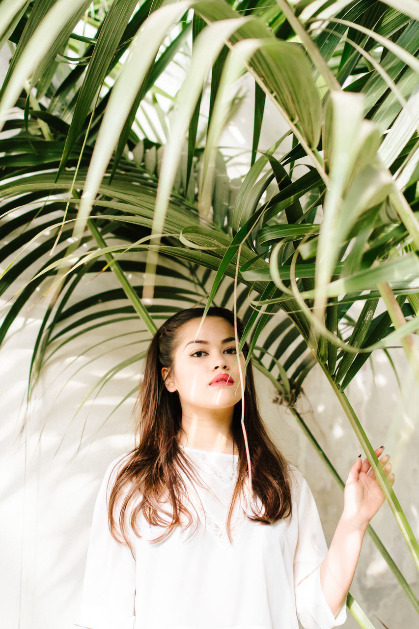 young adult, young women, person, lifestyles, looking at camera, portrait, leisure activity, long hair, front view, smiling, casual clothing, tree, headshot, standing, waist up, happiness, plant