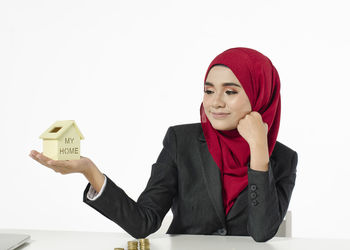 Portrait of a smiling young woman against white background