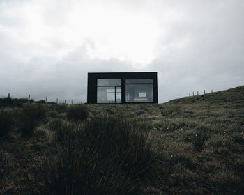 Abandoned house on field against sky