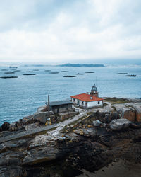 Scenic view of lighthouse by sea against sky