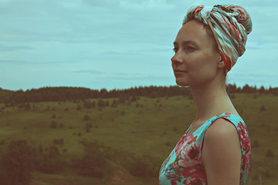 Side view of thoughtful woman with head wrapped in headscarf looking away during dusk
