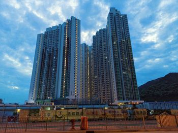 Low angle view of buildings against cloudy sky