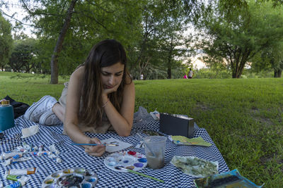 Portrait of young woman sitting on field