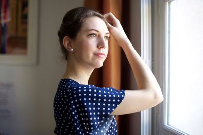 Portrait of beautiful young woman looking away at home