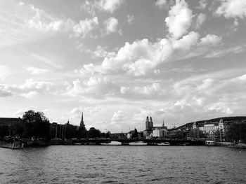 Scenic view of river by buildings against sky