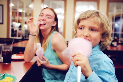 Mother with son eating cotton candy at restaurant