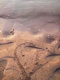 High angle view of heart shape drawn on shore at beach