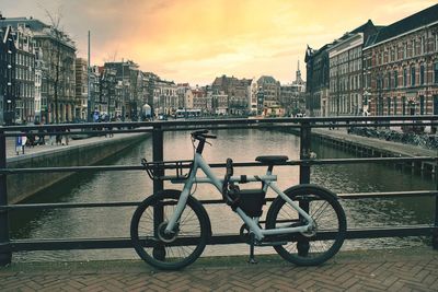 Bicycle on the bridge by the canal with colorful architecture in background in amsterdam,netherland