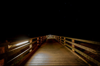 Illuminated bridge against sky at night