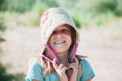 Close-up portrait of girl smiling while holding basket on field