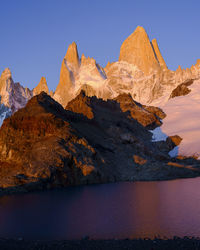 Scenic view of lake and mountains against blue sky