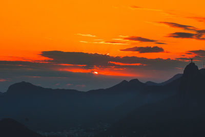 Scenic view of silhouette mountains against romantic sky at sunset