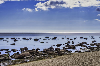 Sand stone boulders seascape with calm water against blue skies