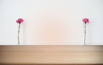 Flower vase on table against wall