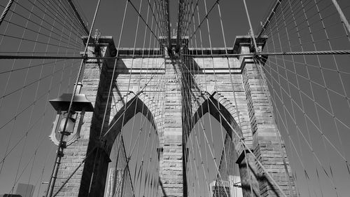 Low angle view of suspension bridge against sky