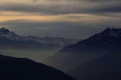 Scenic view of mountains against cloudy sky