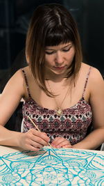 Woman painting in paper at home