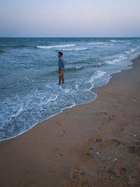Man standing on beach against sky