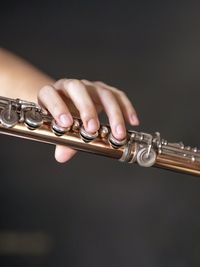 Close-up of hand playing guitar against black background