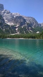 Scenic view of lake and mountains against clear blue sky