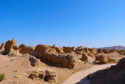 Rock formations against clear blue sky