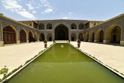 View of swimming pool by building against sky