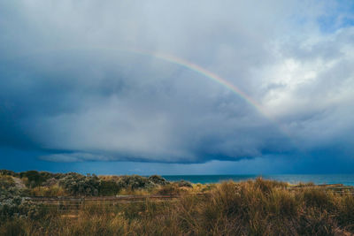 Scenic view of rainbow over landscape against sky