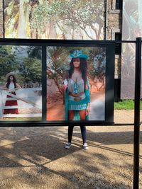 Full length portrait of girl standing against tree