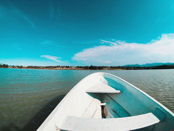 Swimming pool by lake against blue sky