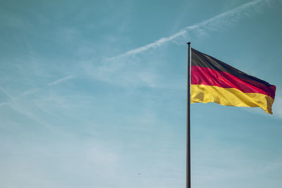 Low angle view of flags against blue sky