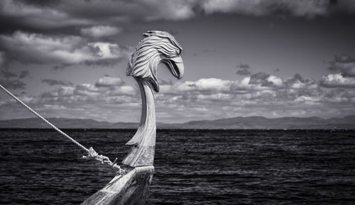 Bird flying over sea against sky